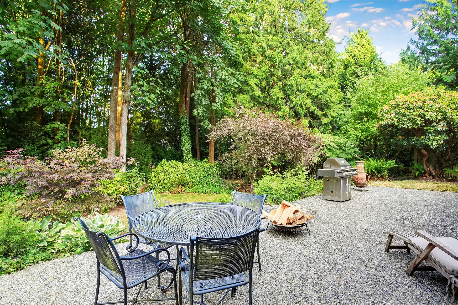 A patio with a table and chairs and a fire pit.