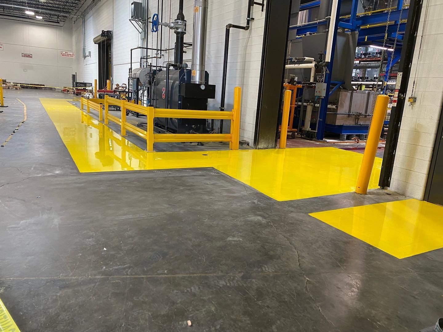 A warehouse with a yellow floor and a yellow barrier.