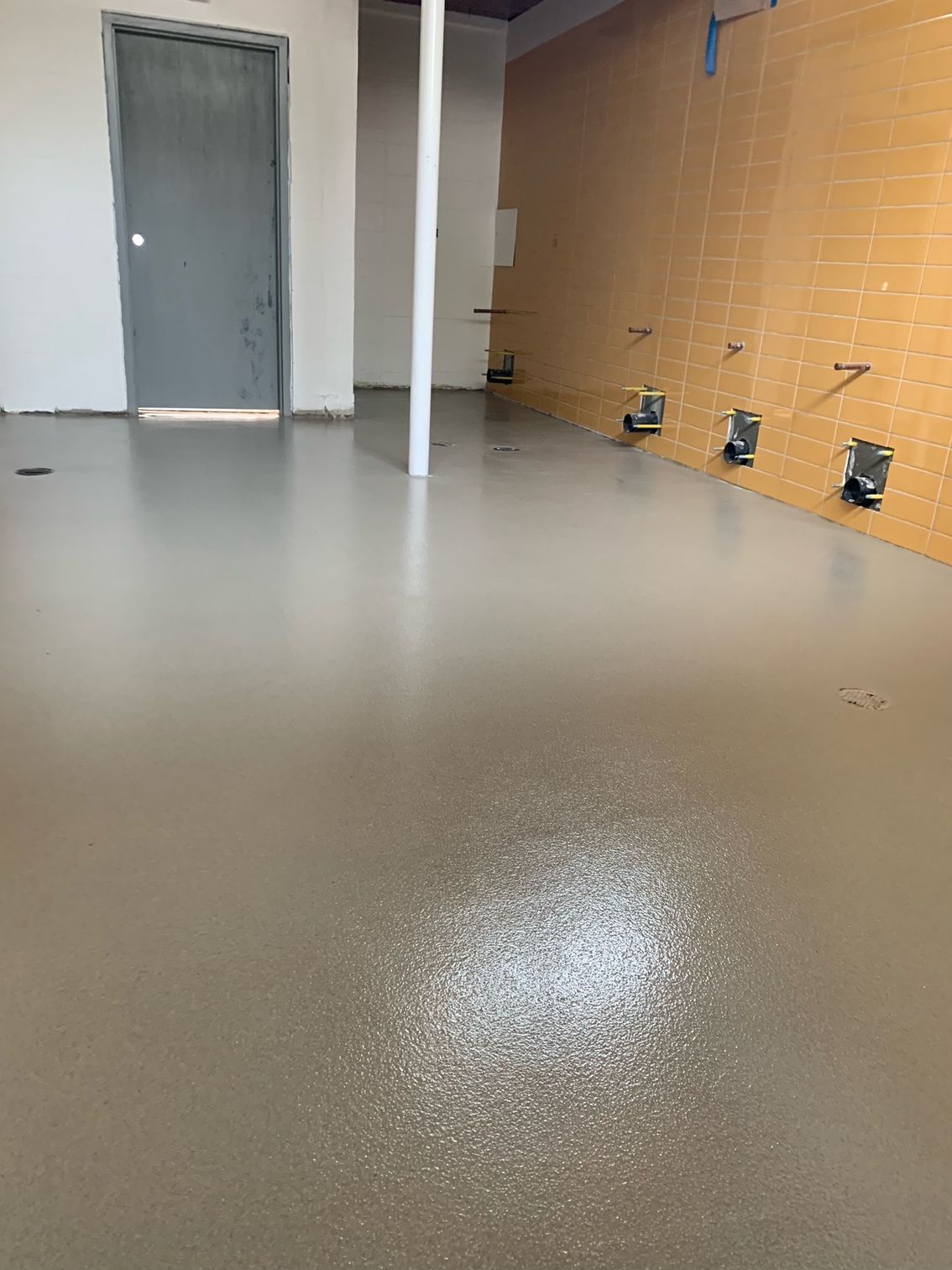 A room with a concrete floor and a door.