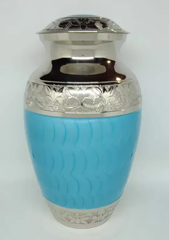 A blue and silver urn is sitting on a white surface.
