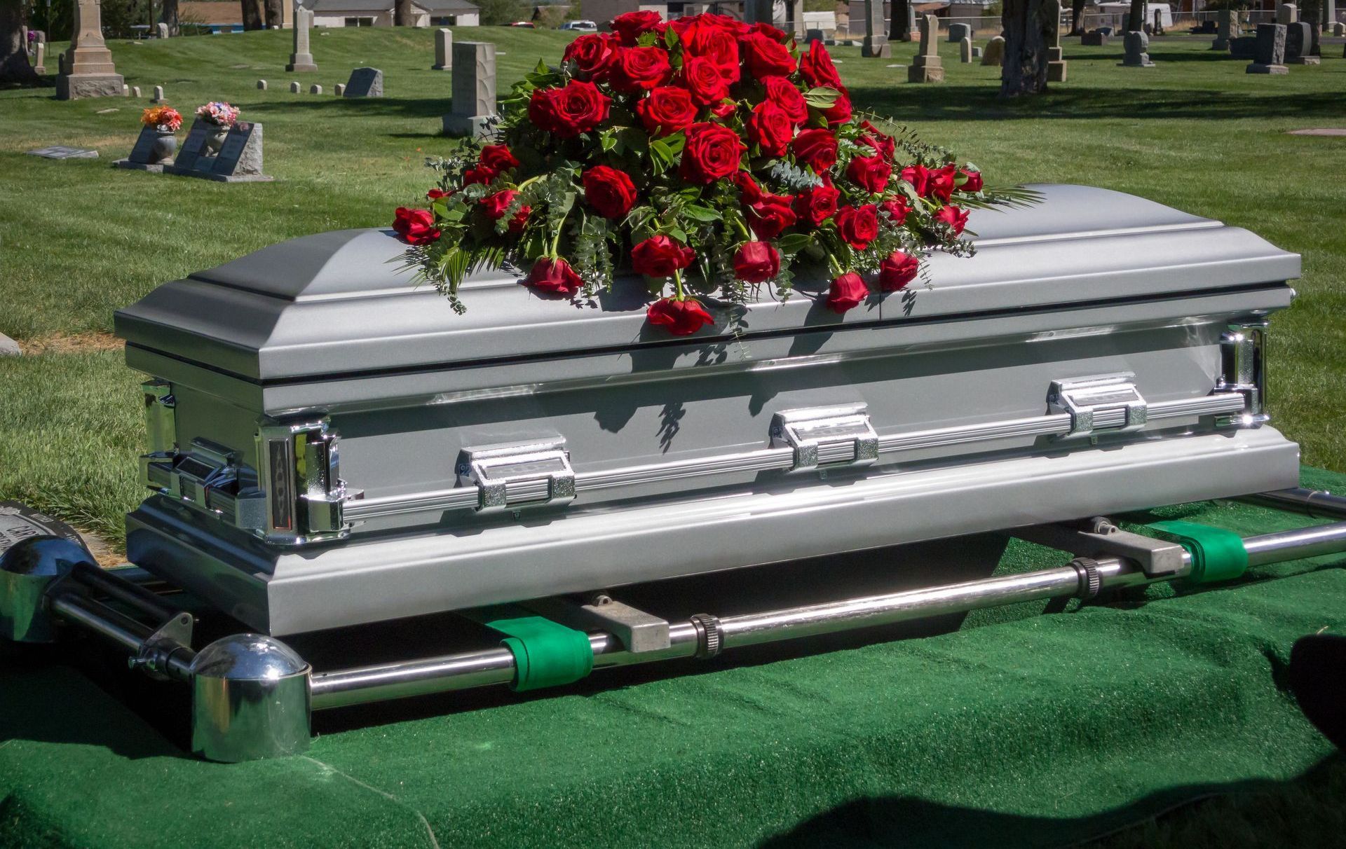 A wooden coffin with flowers on top of it