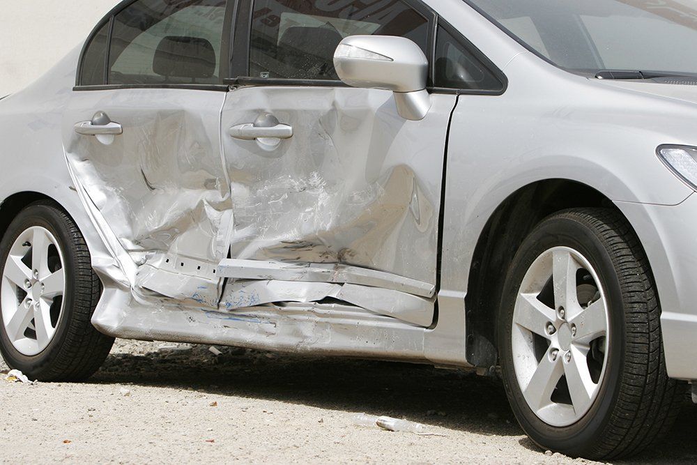 Silver Car with a Large Dent in the Side | Colorado Springs, CO | Millennium Auto Craft