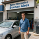 Man standing beside a silver car outside Taller Mecánico Buenos Aires garage