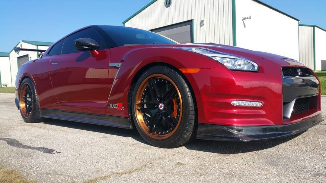 Red sports car parked outside a building on a sunny day