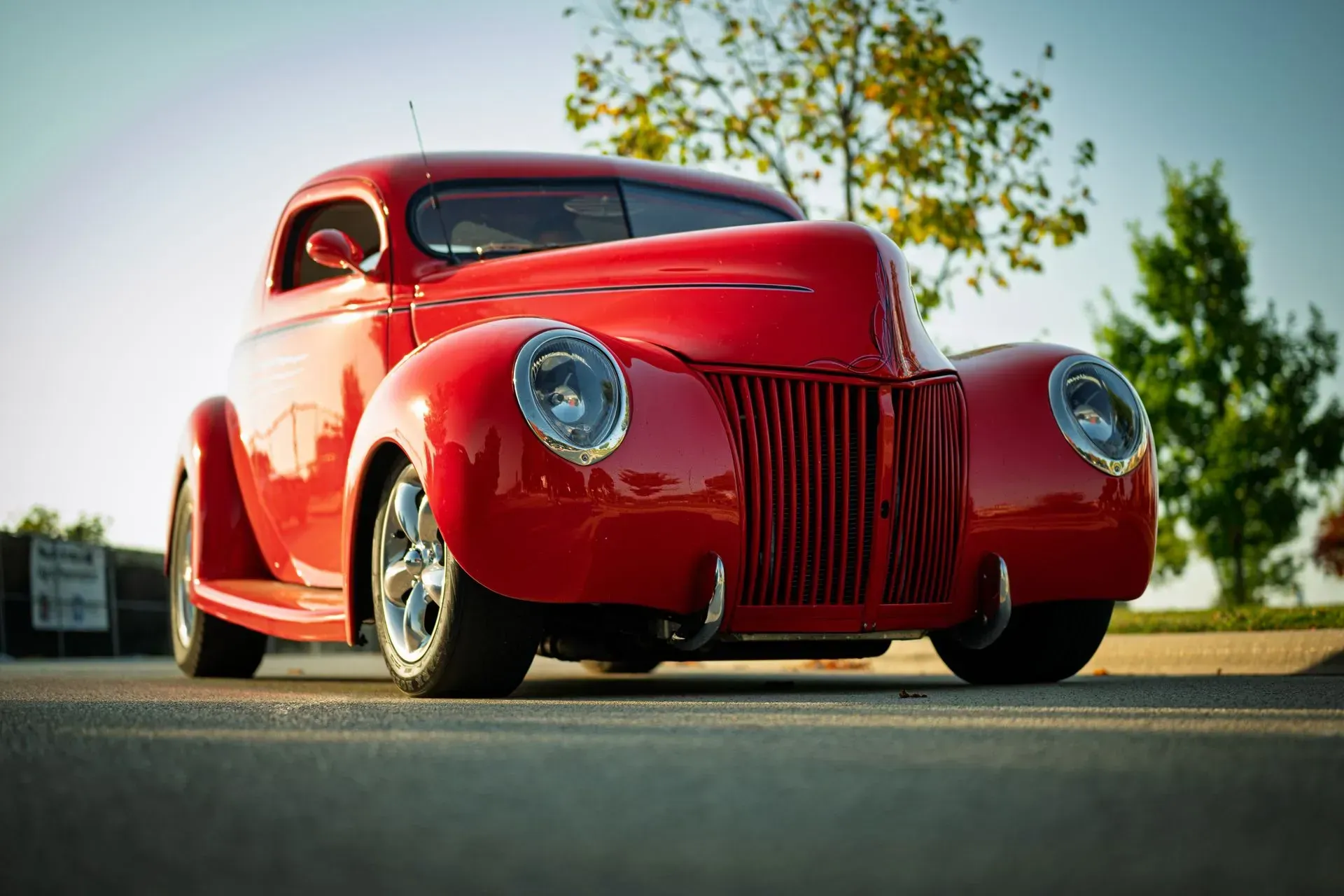 Red vintage coupe parked outdoors on a sunny day