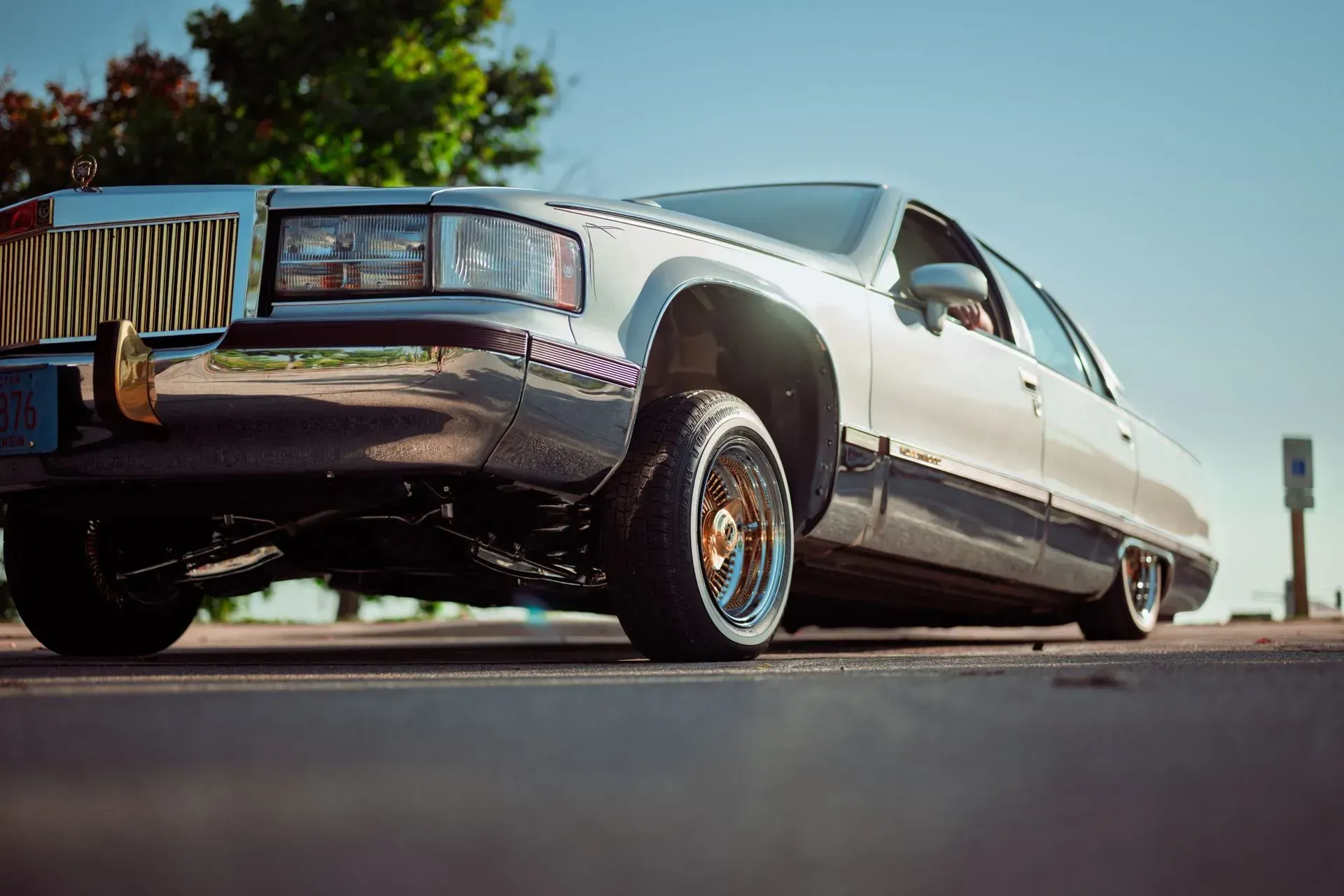 Lowrider car with raised front end parked on a sunny street