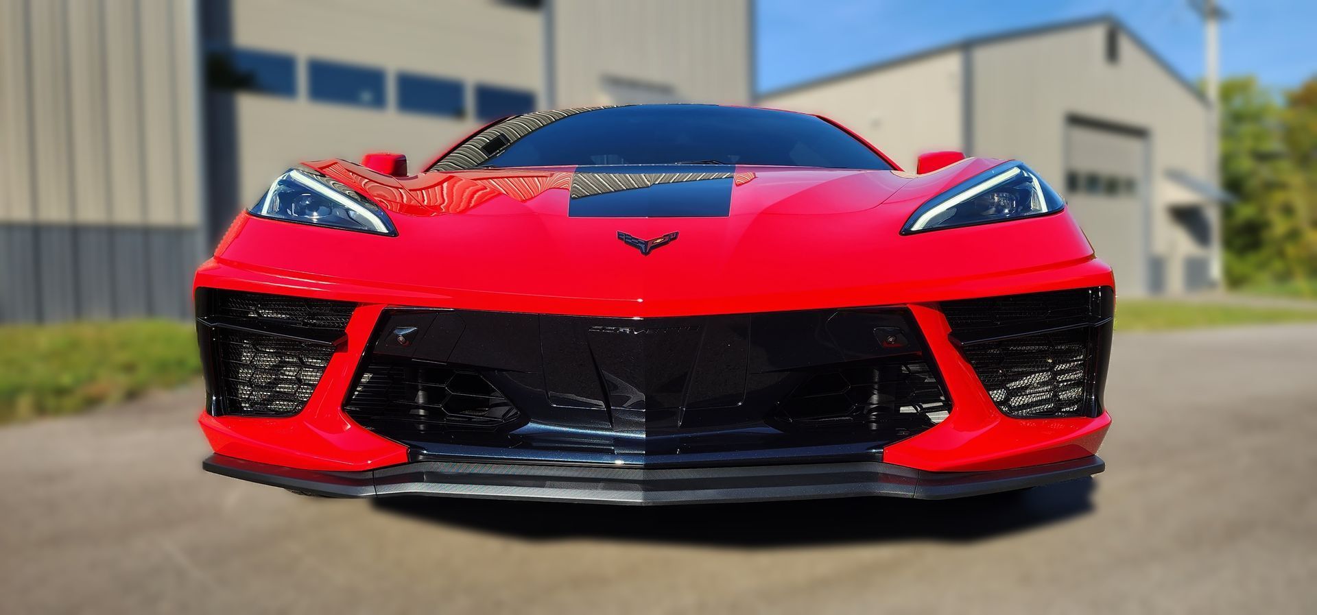 Red sports car front view parked outdoors on a sunny day