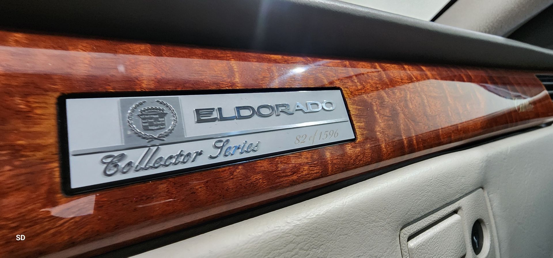 Close-up of an Eldorado “Collector Series” dashboard plaque on wood trim inside a car