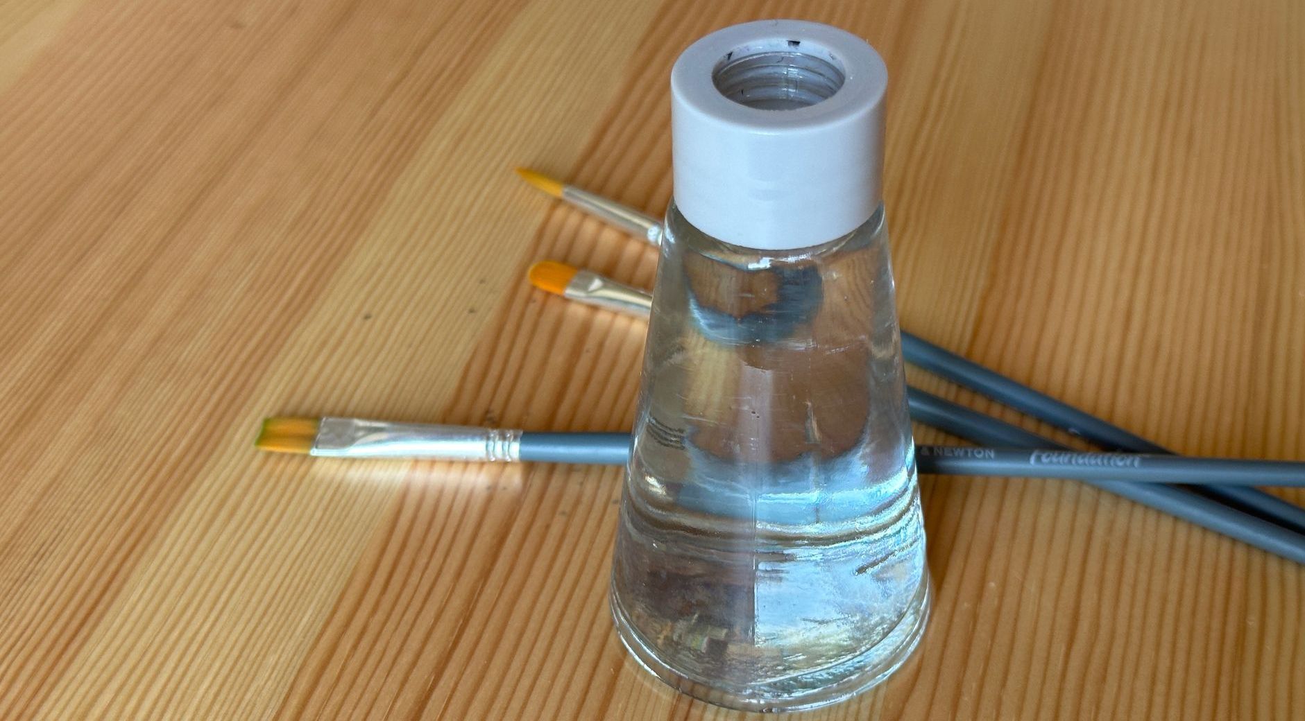 potje met water en kwasten
