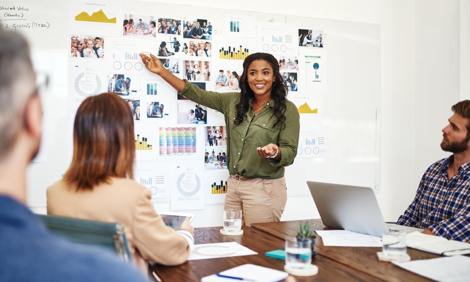 A woman is giving a presentation to a group of people in a conference room.