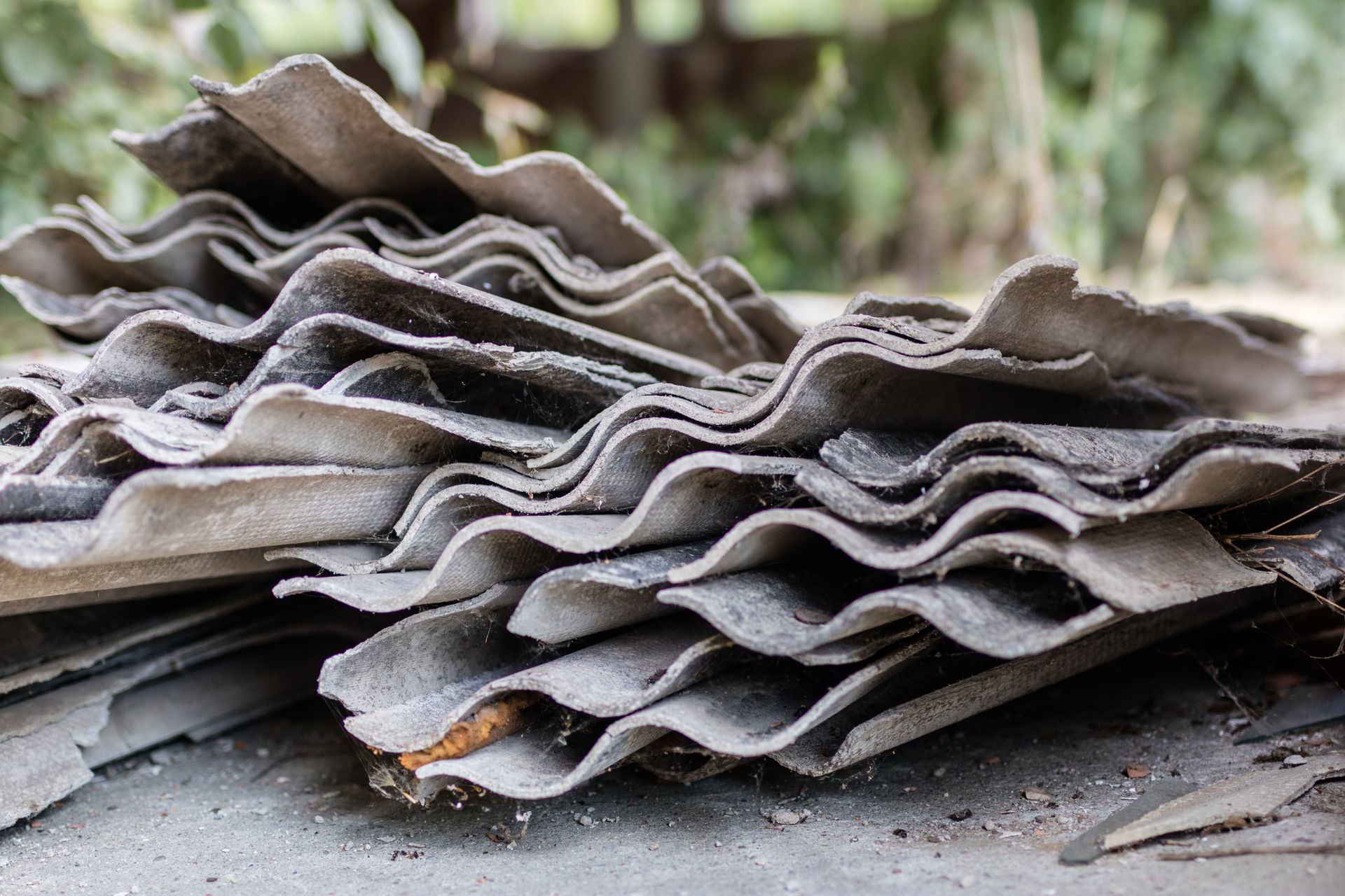 Pile of stacked corrugated roofing sheets in gray and brown tones outdoors