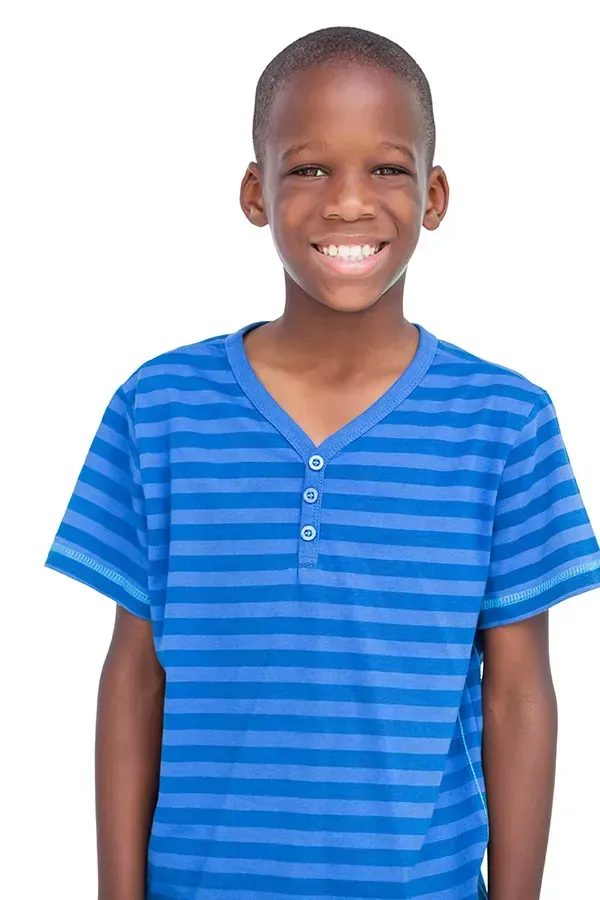 A young boy is wearing a blue striped shirt and smiling.