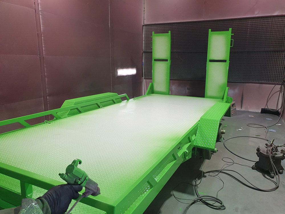 A Green Trailer Is Being Painted in A Paint Booth — ASSB Armidale Sand And Soda Blasting In  Armidale, NSW