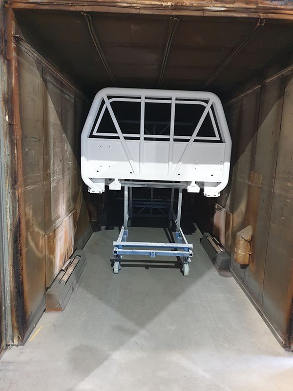 A White Ute Is Sitting Inside Of A Paint Area — ASSB Armidale Sand And Soda Blasting In  Armidale, NSW