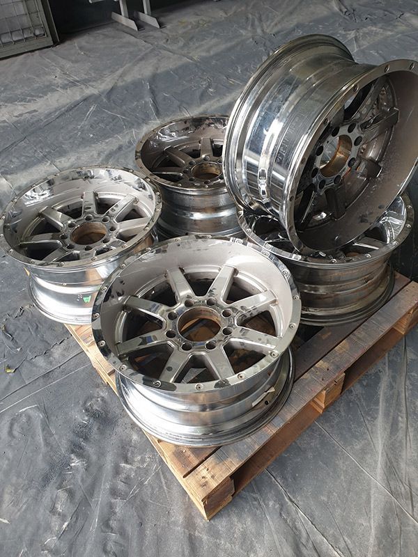A Bunch Of Aluminum Wheels Are Sitting On Top Of A Wooden Pallet — ASSB Armidale Sand And Soda Blasting In Armidale, NSW