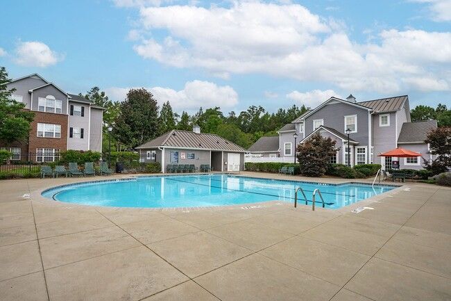 Swimming pool in front of apartment buildings on a sunny day.