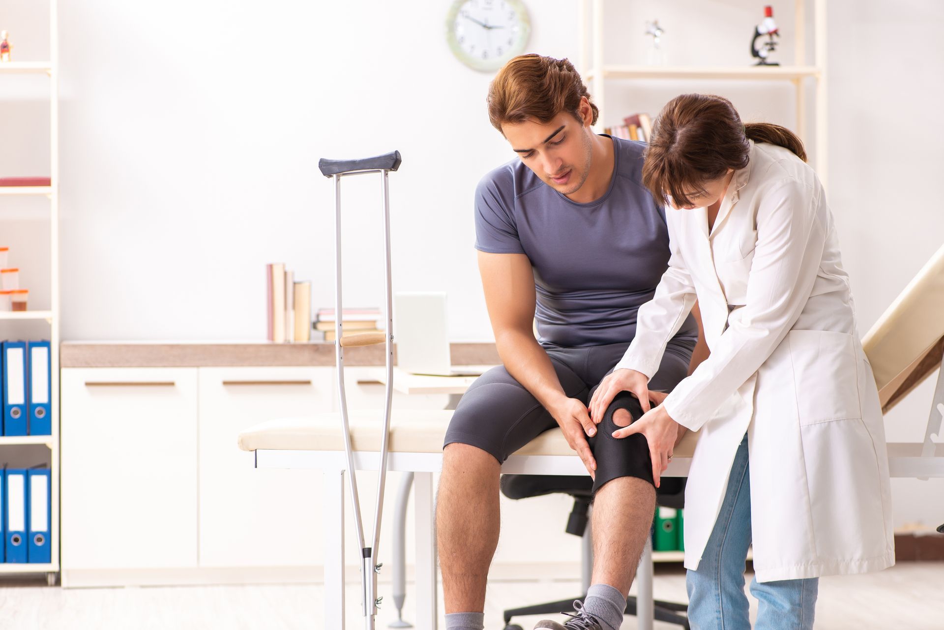 A doctor is checking a patient’s knee.