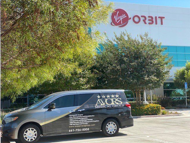 Van in front of a Virgin Orbit building. The van is labeled