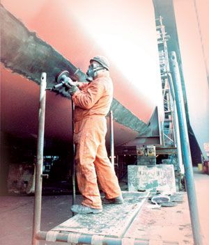 A man wearing a gas mask is standing on a scaffolding
