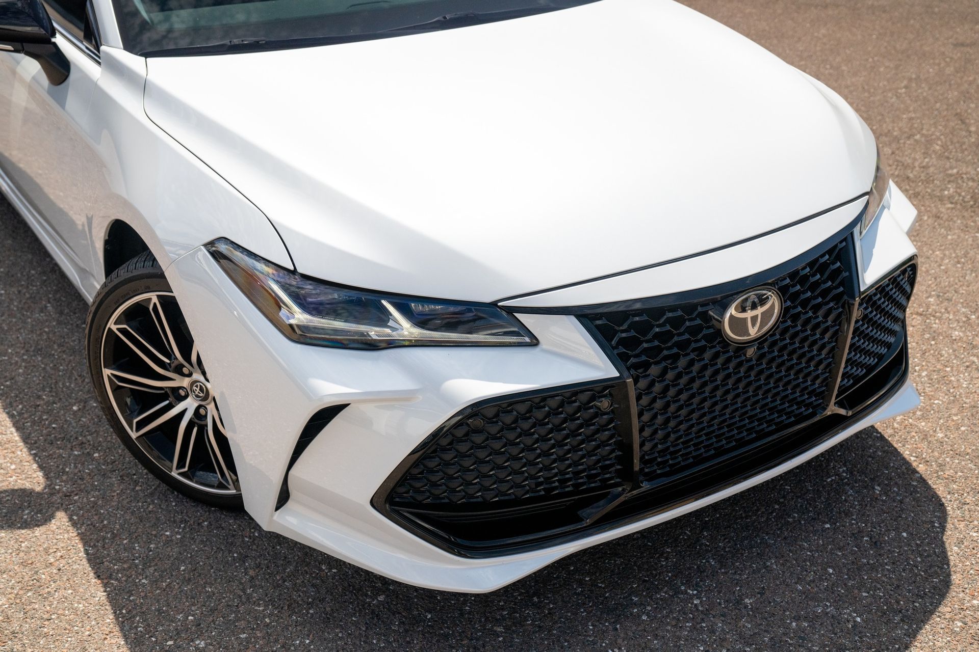 White Toyota Avalon car front, black grille, daytime.