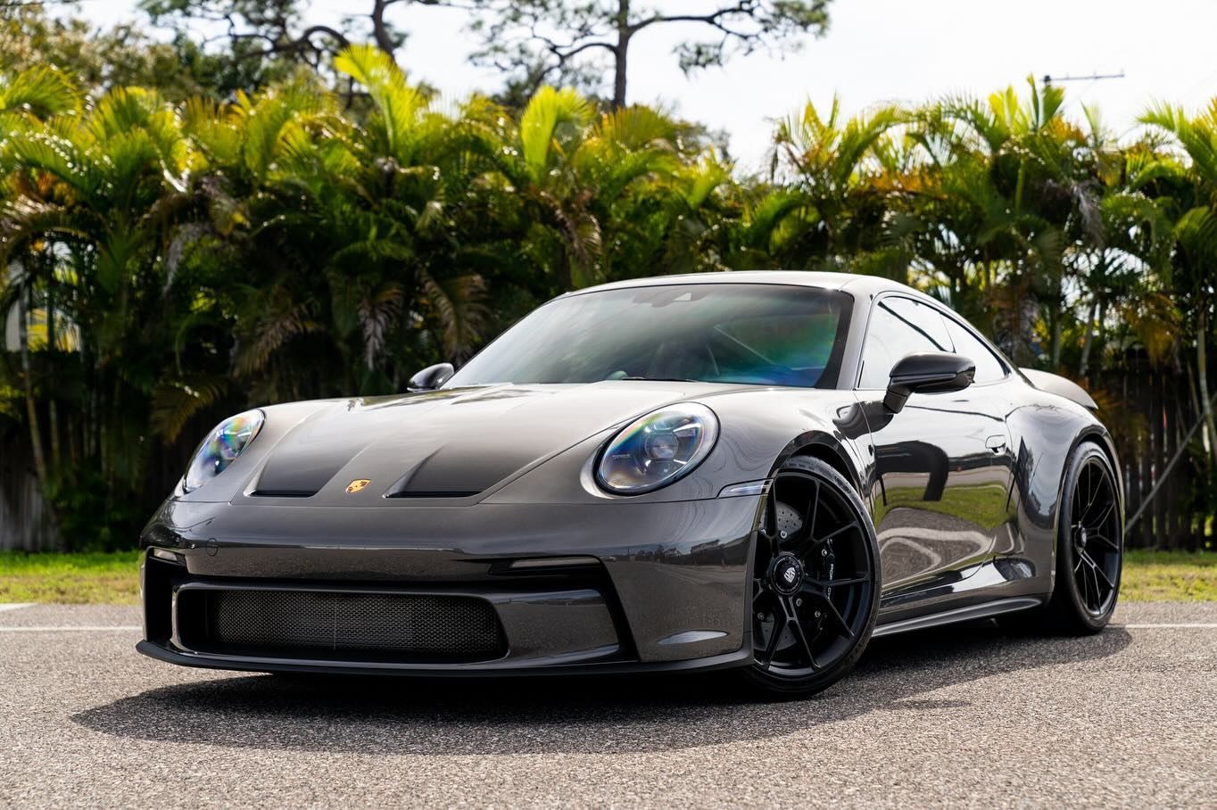 A gray porsche 911 gt3 is parked on the side of the road.