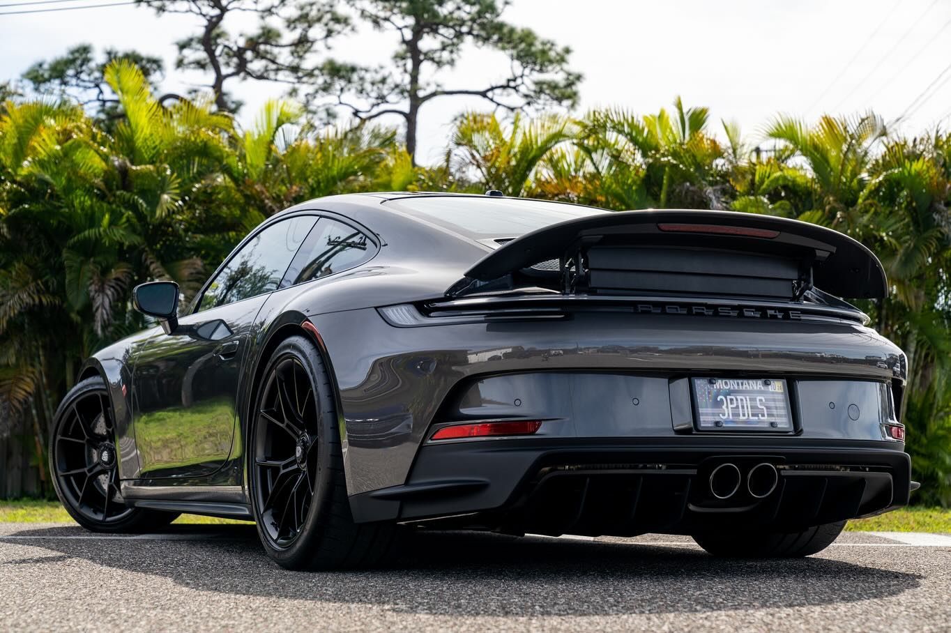 A gray porsche 911 gt3 is parked on the side of the road.