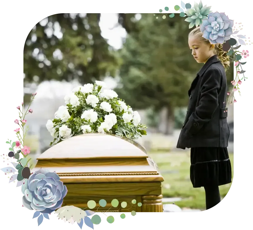 Child standing beside a flower-covered coffin in a cemetery, framed by floral decorations