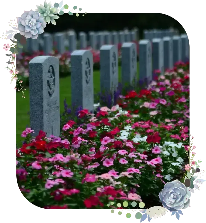 Rows of gray gravestones beside a path of pink and white flowers, framed by floral decorations