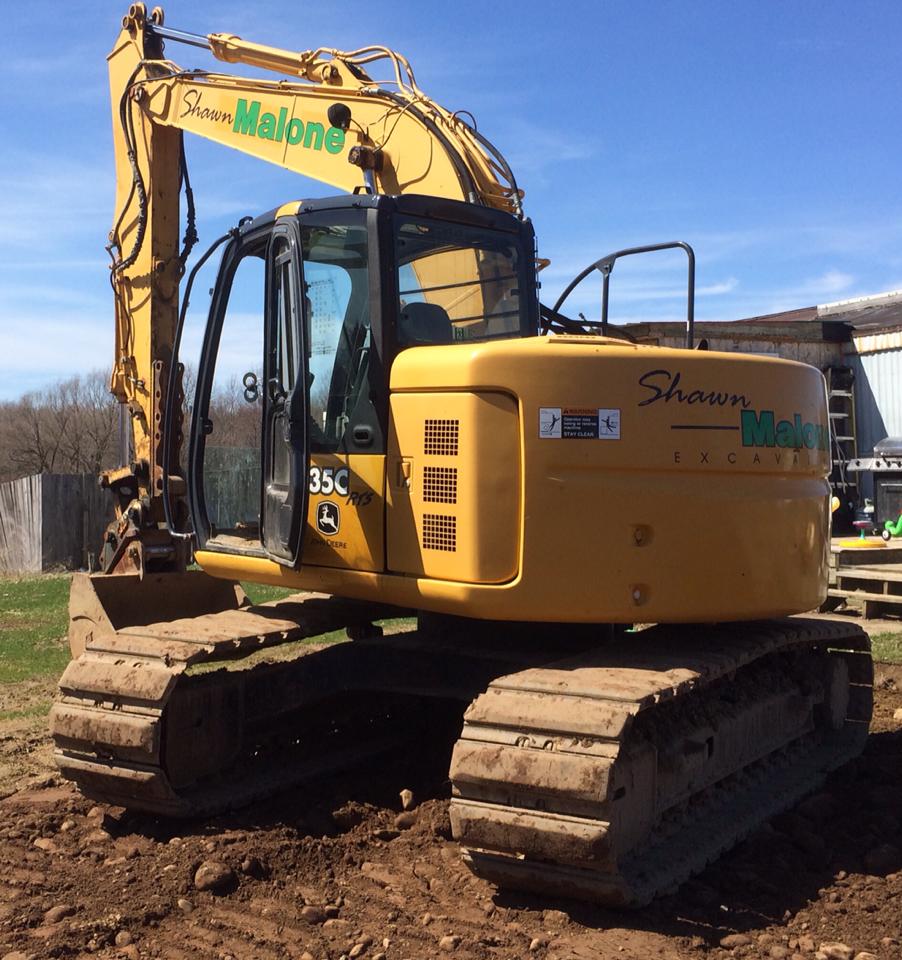 Yellow John Deere 35C excavator on a construction site.