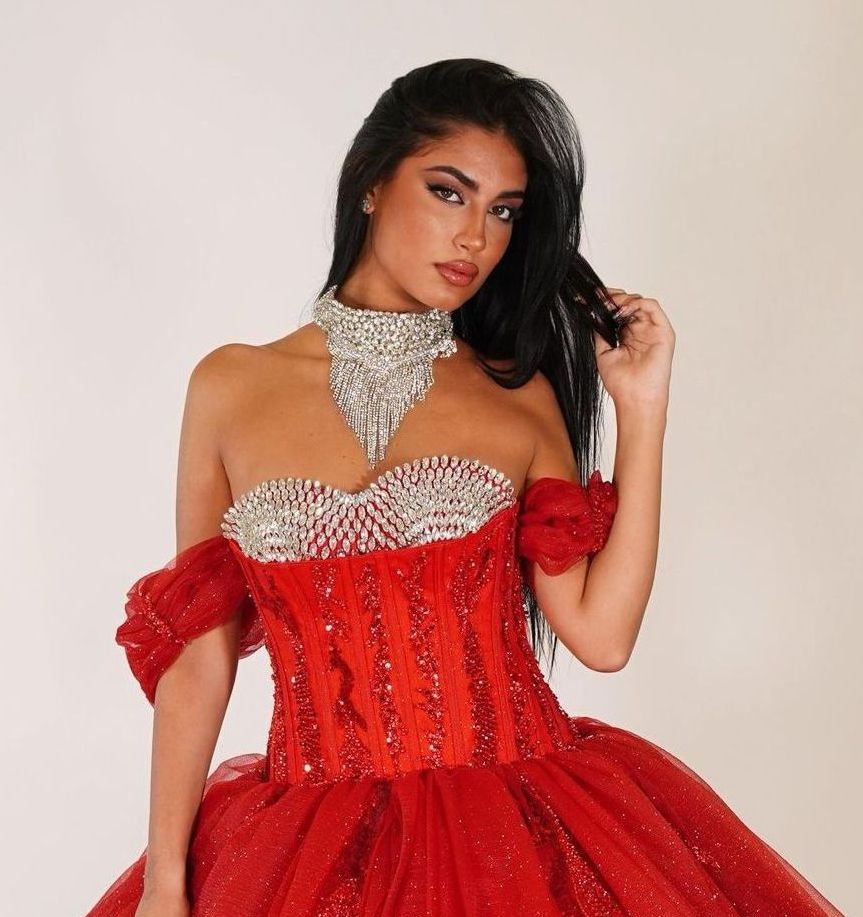 Una donna con un vestito rosso decorato con strass