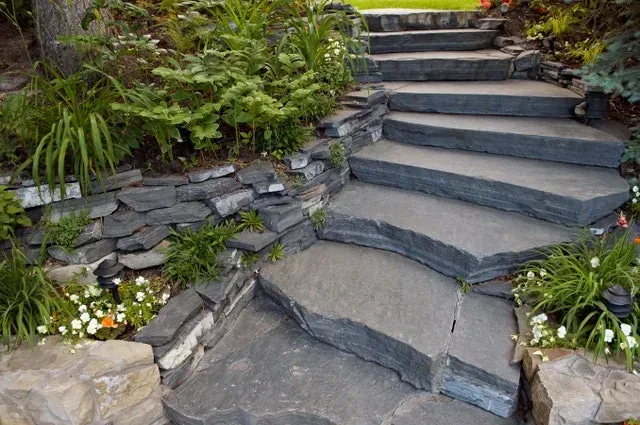 Stone garden steps surrounded by lush greenery and flowers