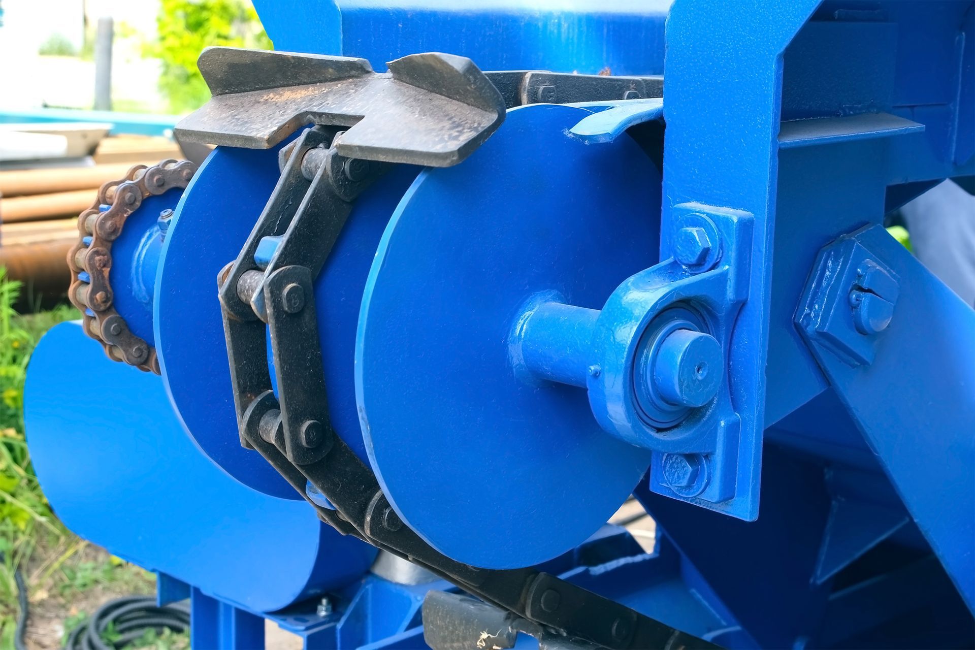 Mechanism of an industrial conveyor belt for moving logs from a woodworking machine.