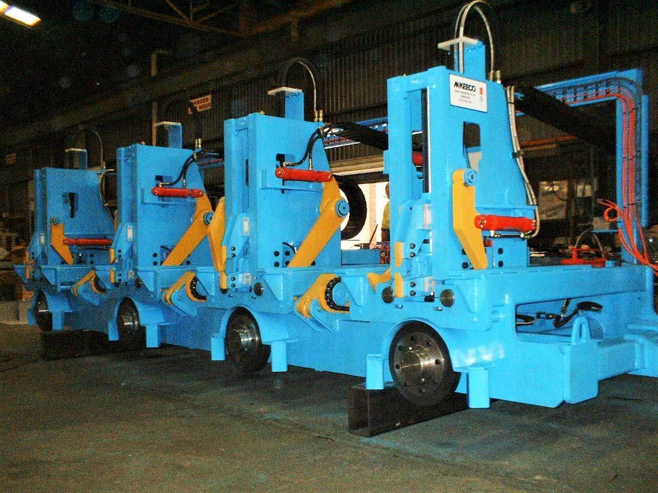 Blue industrial machinery with yellow and red accents, in a factory setting.