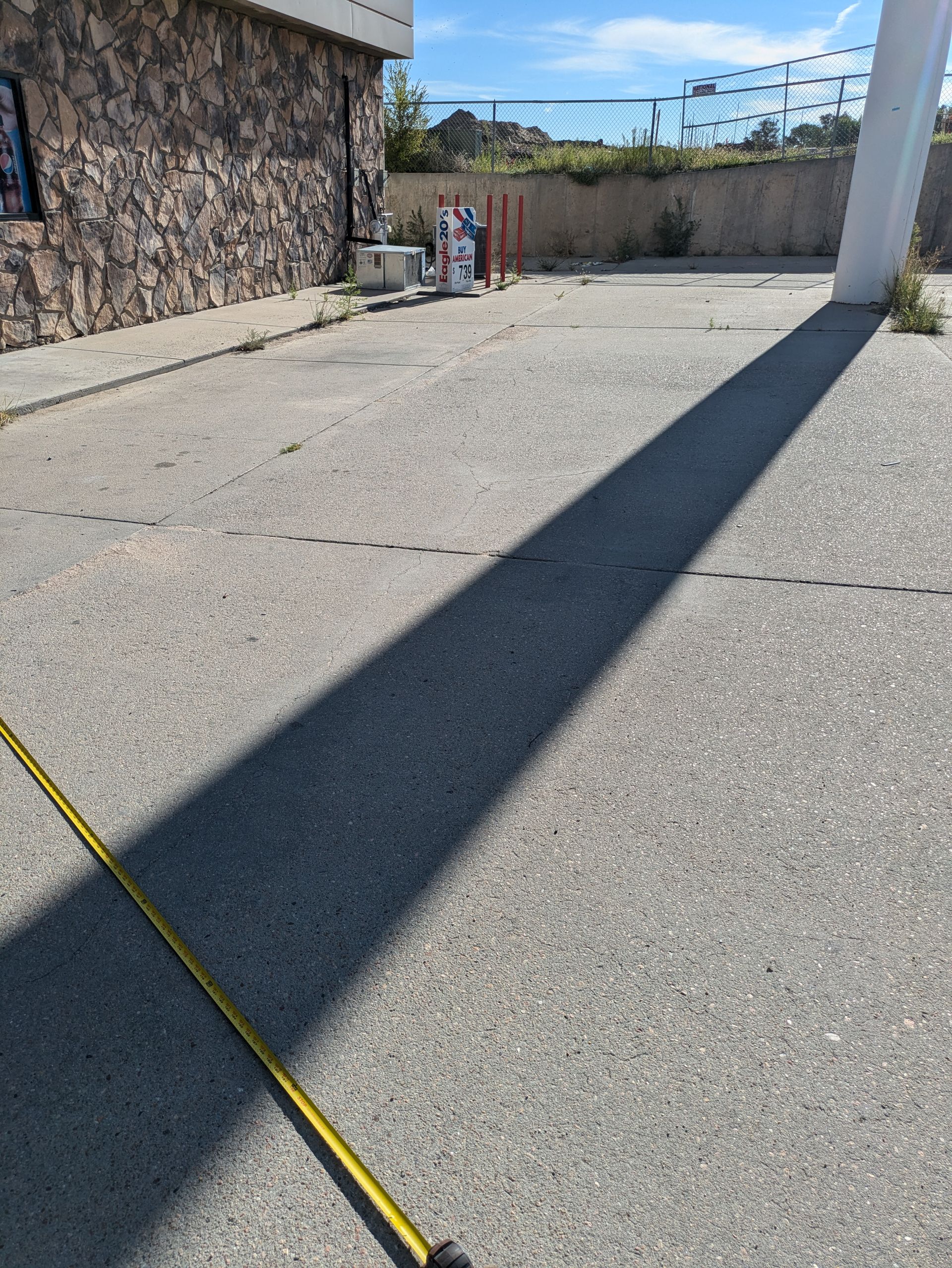 A measuring tape is laying on the ground in front of a building.
