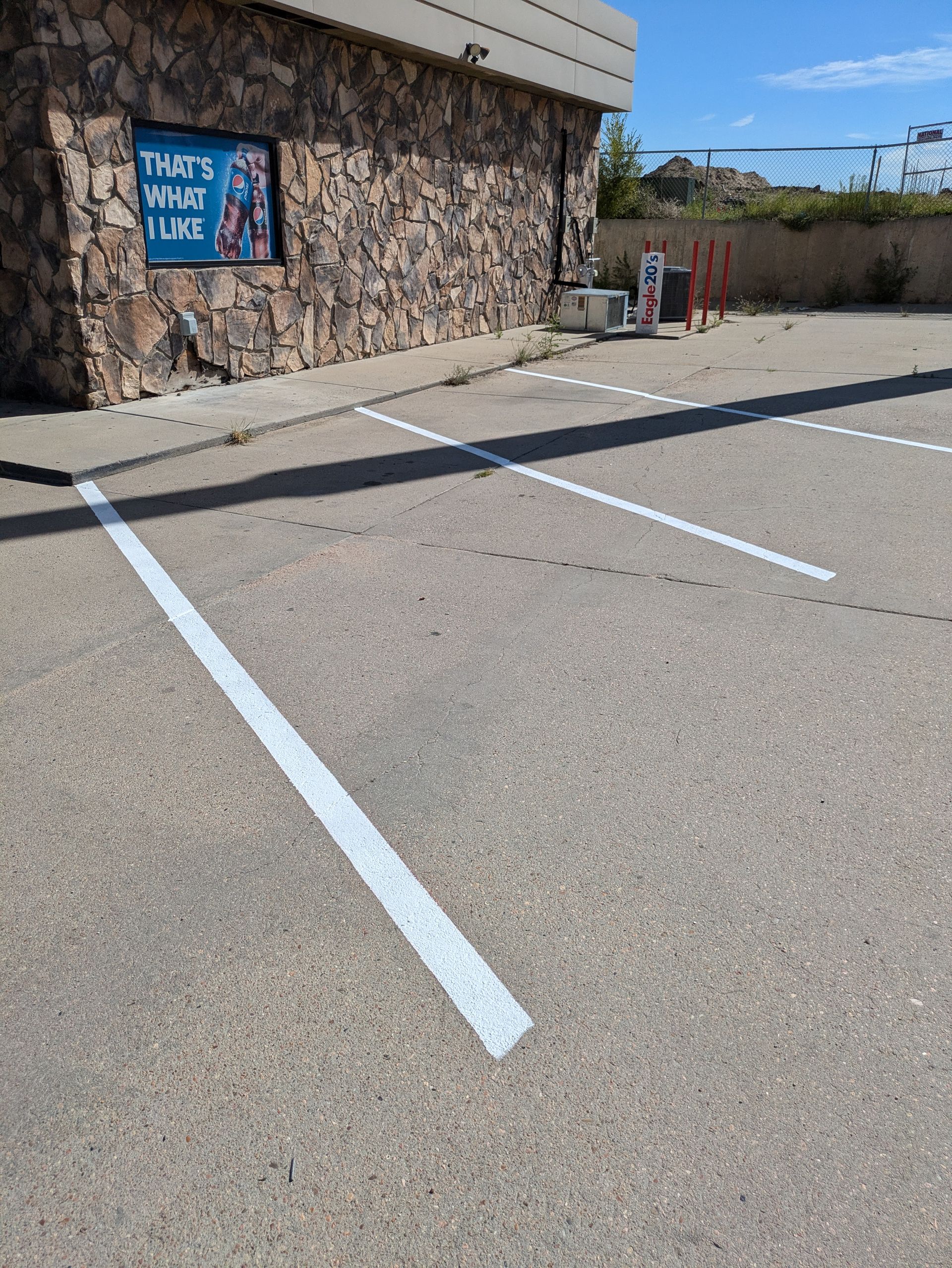 A parking lot with a stone building in the background