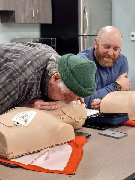 A man in a green hat is laying on a mannequin