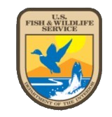 U.S. Fish & Wildlife Service shield logo with blue flying duck over marsh and mountain scene