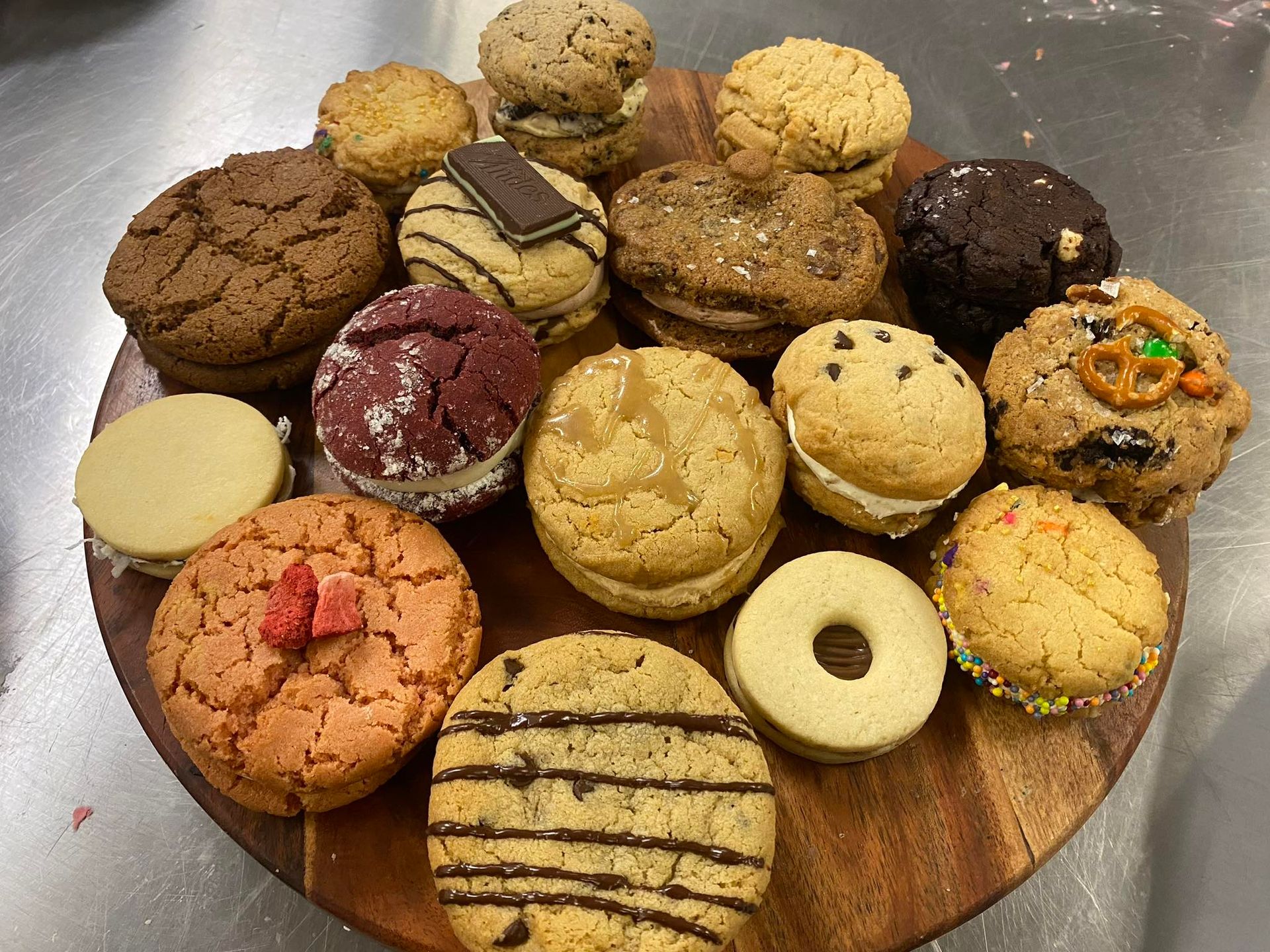Variety of colorful cookies on a wooden board.
