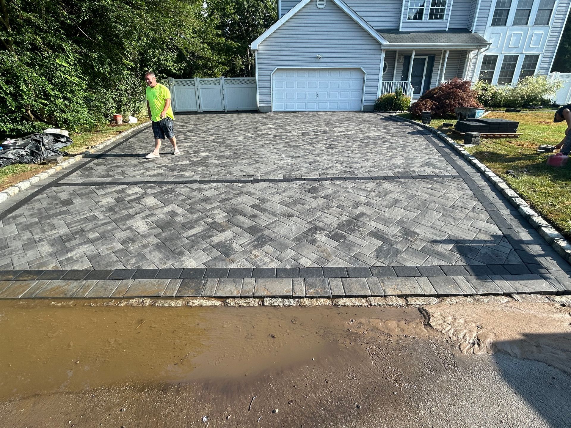 Paver driveway showing grey paving patterns and a contrasting dark perimeter