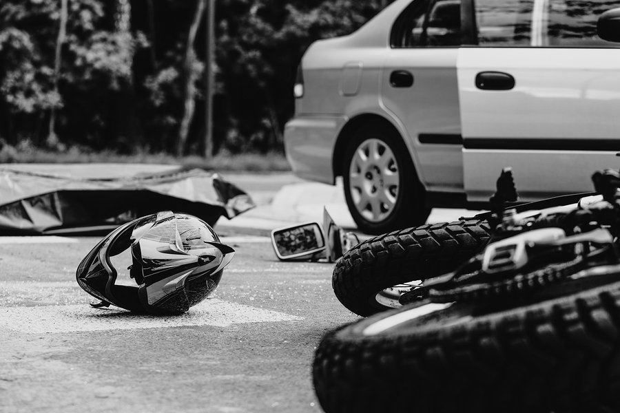 Bicycle crash scene with a helmet and overturned bike on pavement beside a parked car