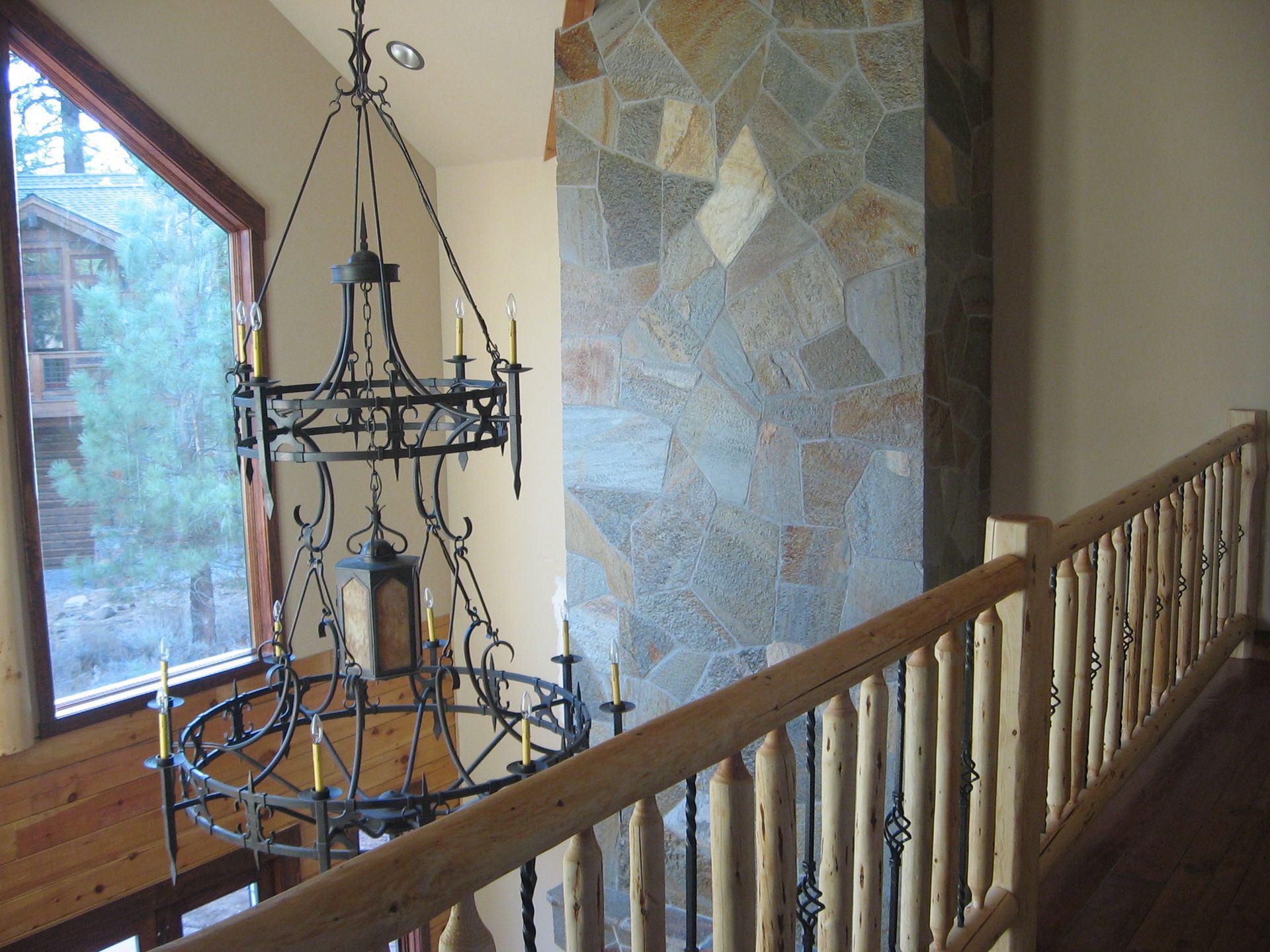 A staircase with a wrought iron chandelier hanging from the ceiling