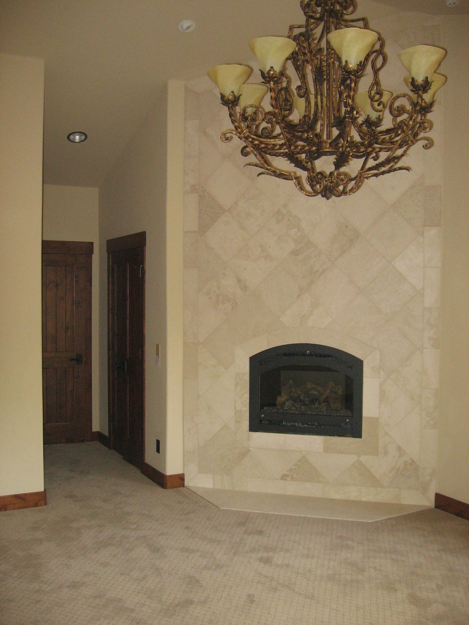 An empty room with a fireplace and a chandelier