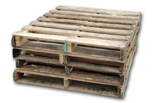 A stack of four weathered, wooden shipping pallets against a white background.