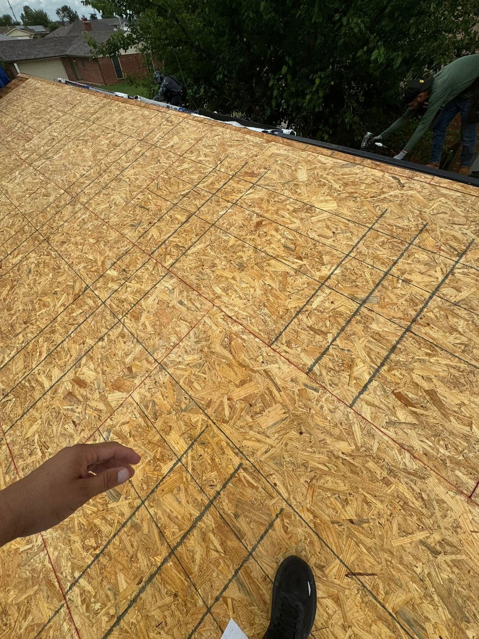 OSB roof decking with hand and shoe visible.