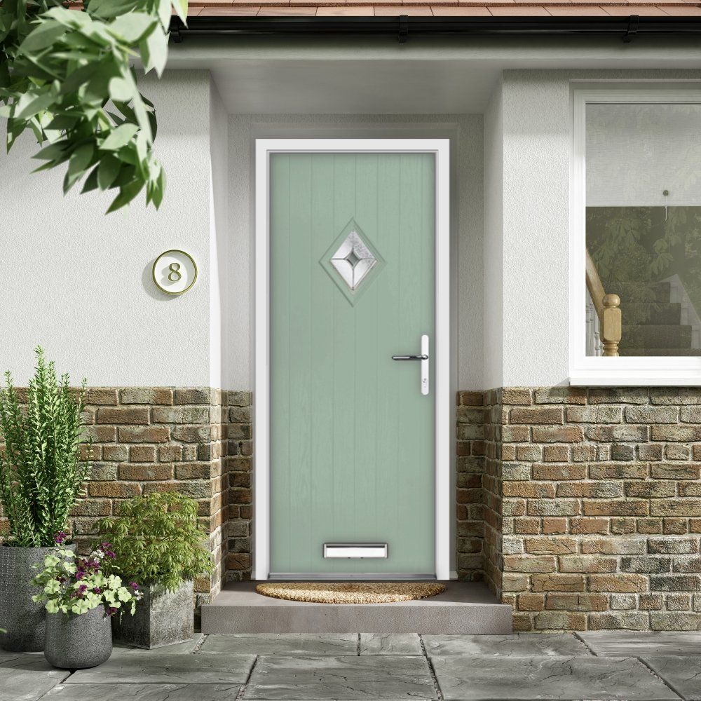 Green front door with diamond window and white trim on a brick and stucco facade.
