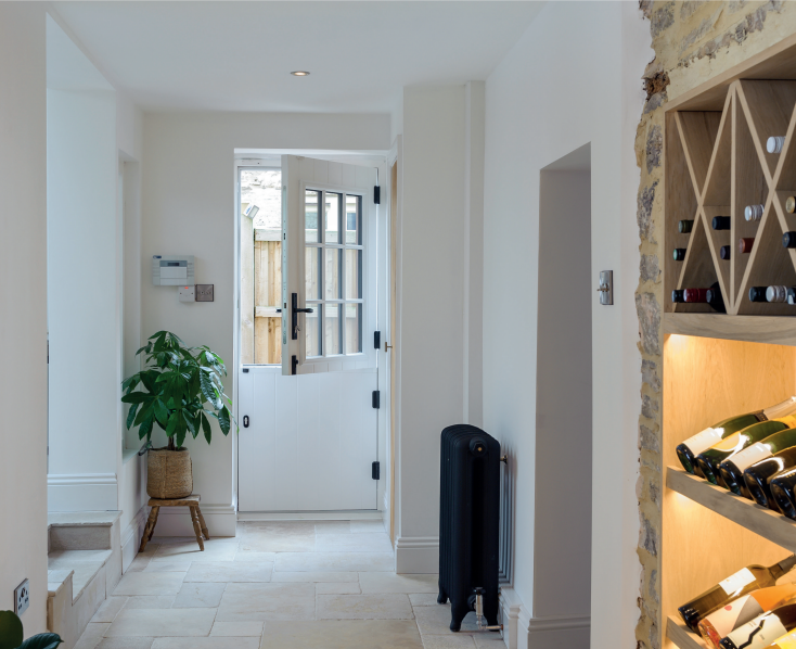 Hallway with open Dutch door to a yard, wine rack built into wall, small radiator.