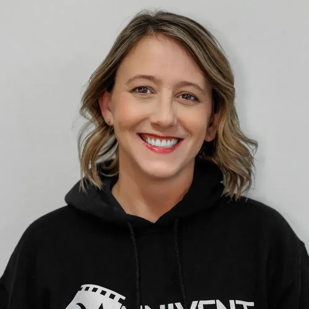 Smiling person in a black hoodie against a light gray background