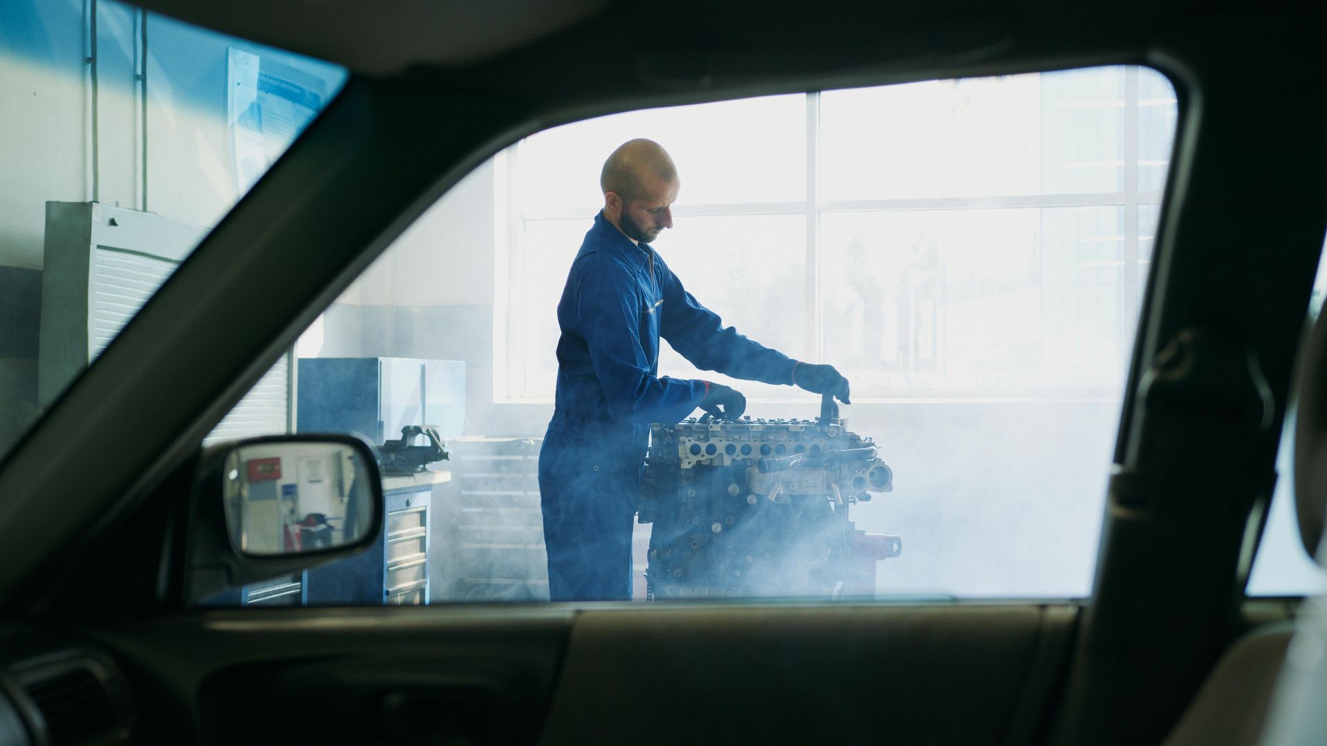 Mechanic working on a car engine inside aKumeu Car Services garage