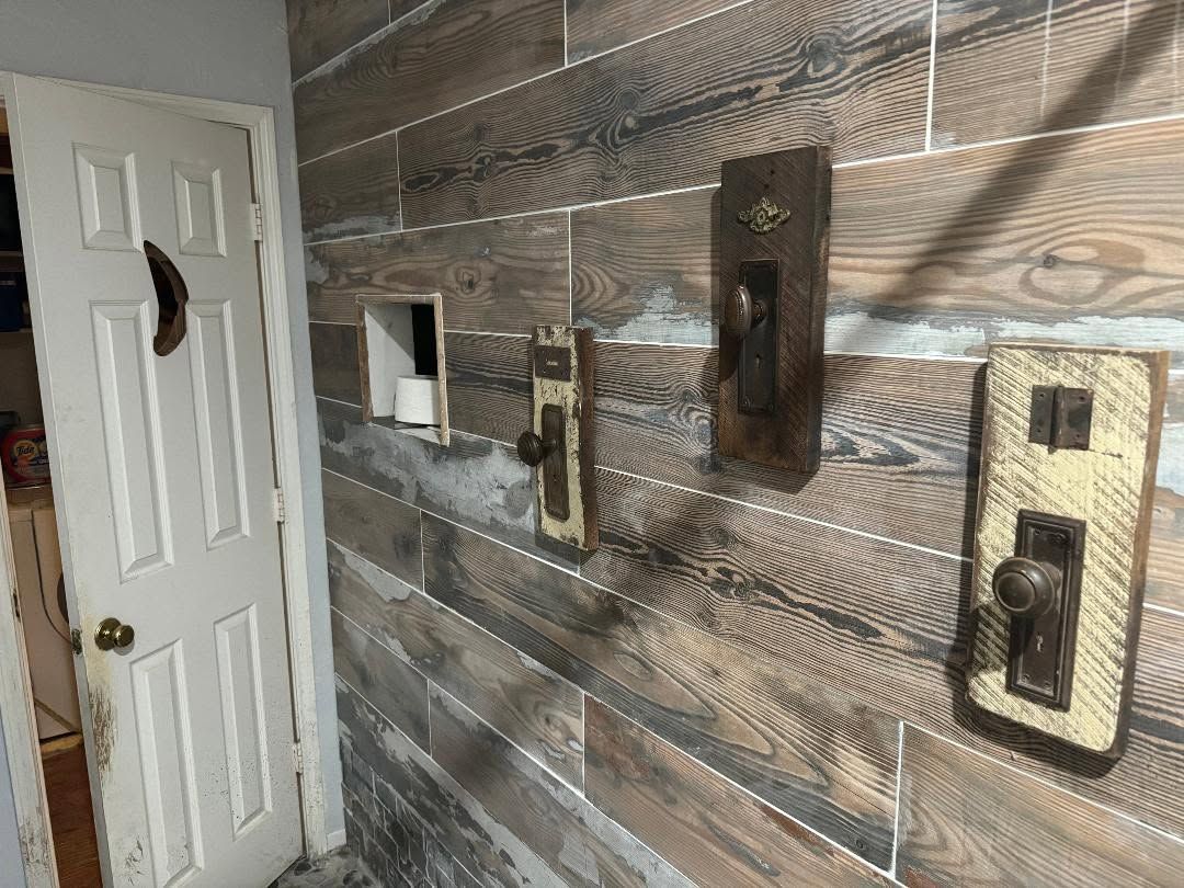 Wall with textured wallpaper and three light switch plates beside a white door.