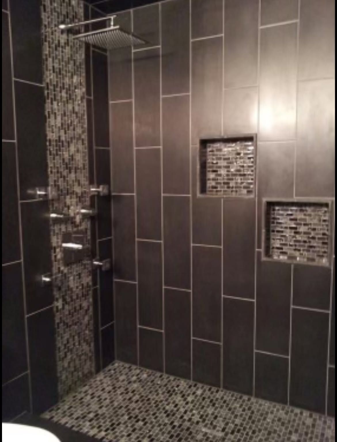 Modern bathroom shower with dark tile and mosaic accent insets